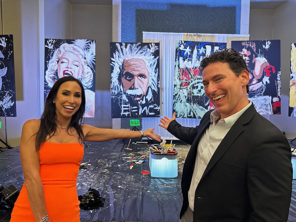 Michael Israel with a guest in front of his live-painted pop-art portraits at the ASES Gala