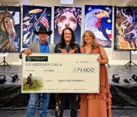 Michael Israel on stage with two guests holding a $71,000 Guardians Gala check