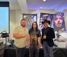 Michael Israel with two guests in front of his paintings